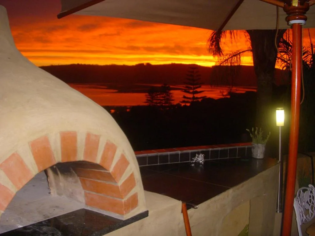 Outdoor deck with pizza oven overlooking lagoon at golden sunset