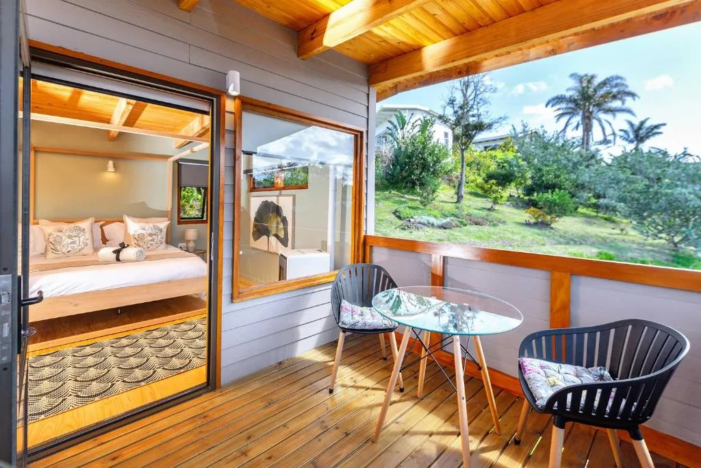 Wooden deck with seating area overlooking lush garden and palm trees