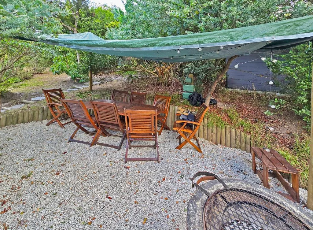 Shaded outdoor seating area with wooden chairs and green awning