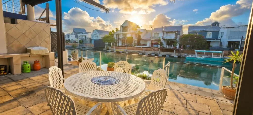 Vela Eleven at Knysna Quays — canal-side deck at sunset, Knysna