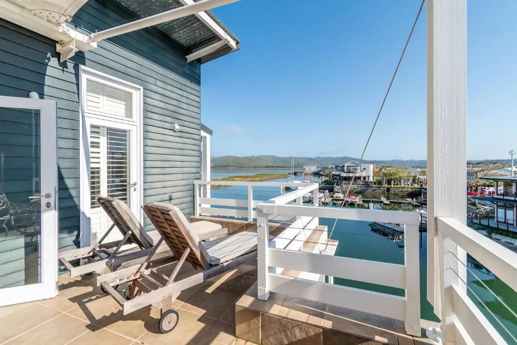Waterfront deck with loungers overlooking Knysna lagoon and boats