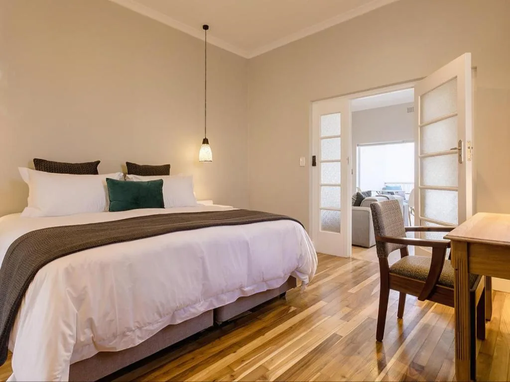 Spacious bedroom with queen bed, pendant lighting, and balcony access