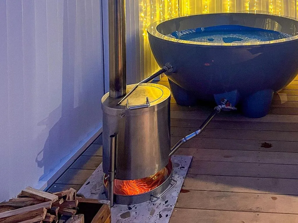 Outdoor braai fire pit with blue soaking tub on wooden deck