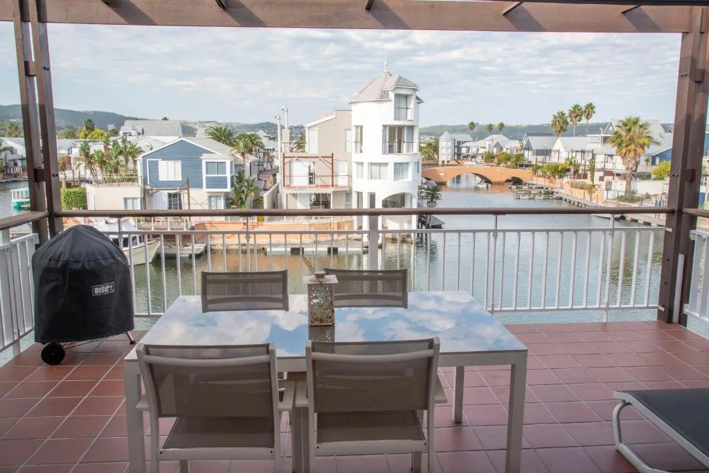 Waterfront deck with dining chairs overlooking lagoon and houses