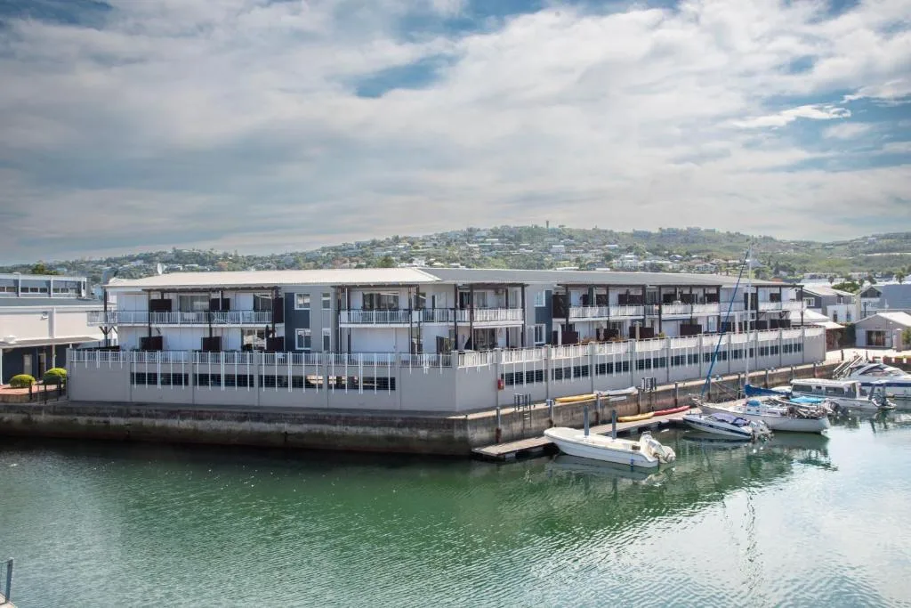 Modern waterfront apartment building with multiple balconies overlooking Knysna harbor