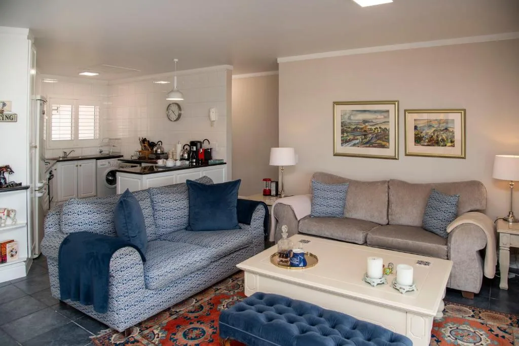 Open-plan lounge with blue patterned sofa, beige armchair, cream coffee table