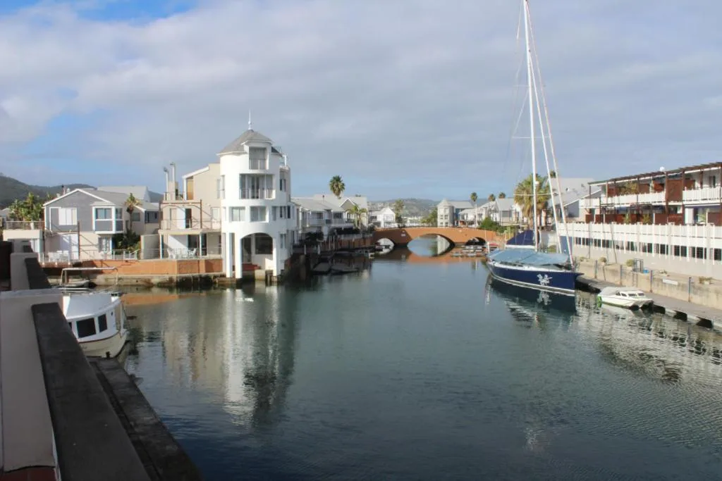 Scenic waterfront view of Knysna Heads with moored sailboats and historic architecture