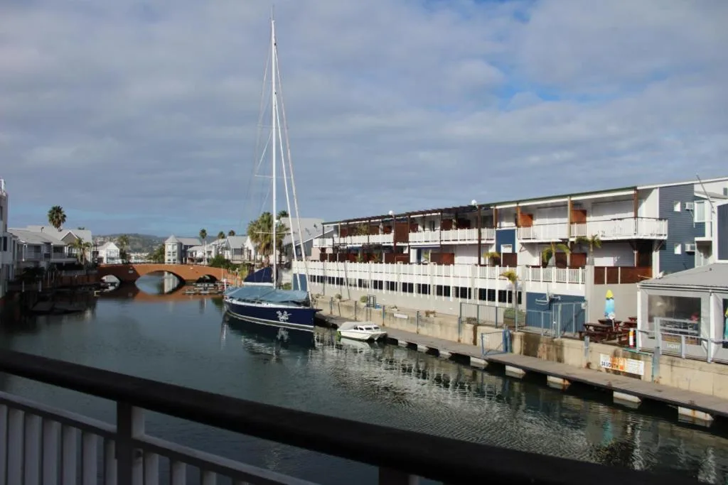 Scenic waterfront view with sailboat and harbor buildings in Knysna
