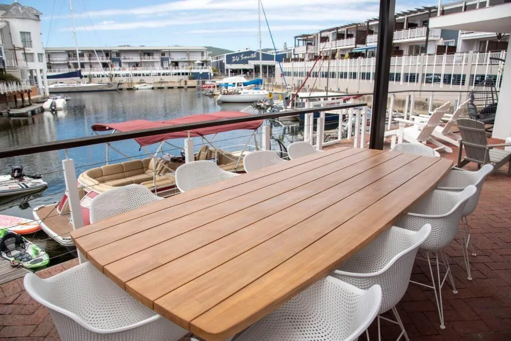 Waterfront deck with wooden dining table and harbor views