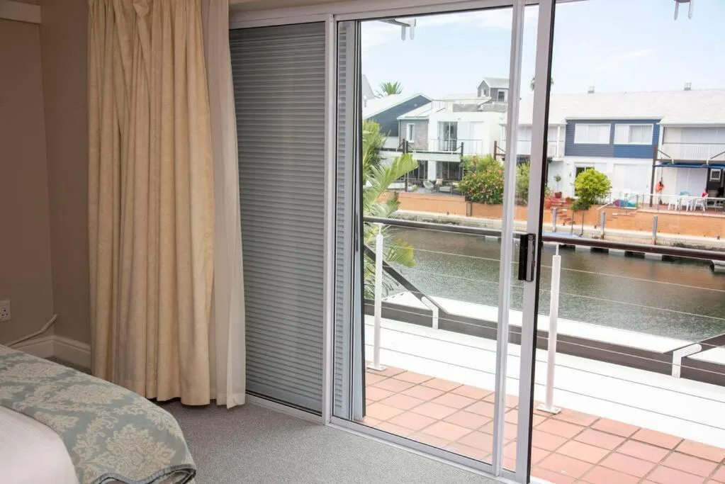 Waterfront view through glass doors overlooking canal and neighboring properties