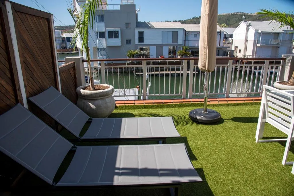 Spacious deck with loungers overlooking canal and waterfront gardens
