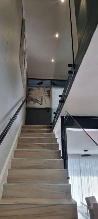 Modern wooden staircase with recessed lighting and metal railings