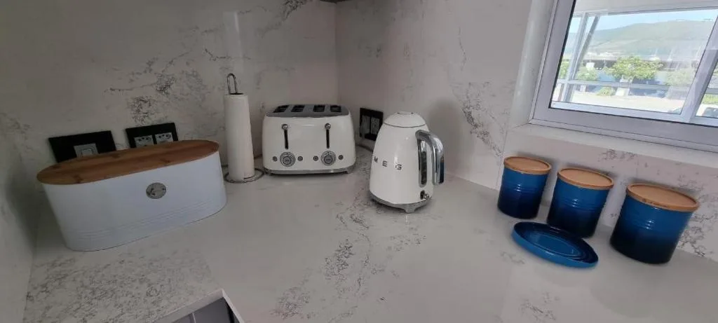 Modern kitchen countertop with white appliances and blue storage containers