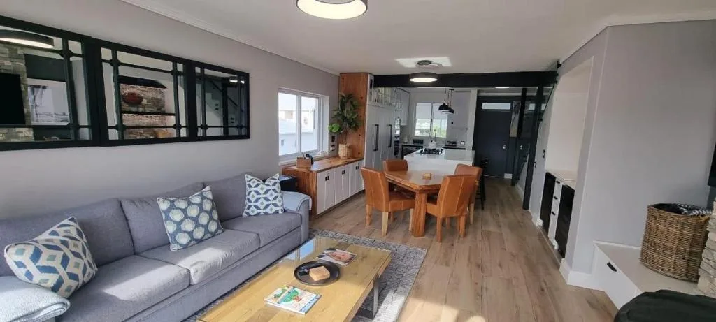 Open-plan lounge with gray sofa, wooden coffee table, and modern décor