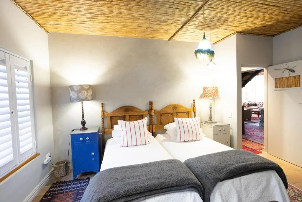Bright bedroom with wooden bed frame and white linens with striped pillows