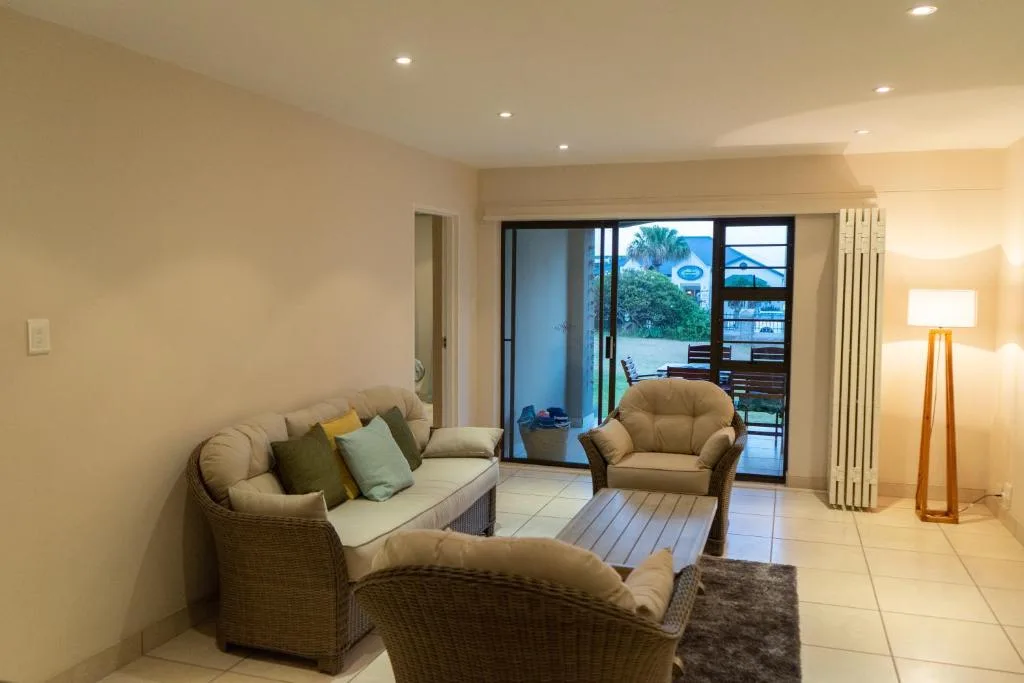 Spacious lounge with wicker seating and sliding glass doors to deck