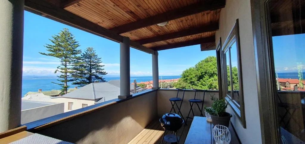 Covered deck with ocean views, seating, and braai area