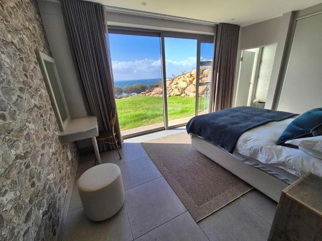 Modern bedroom with ocean view through large glass sliding doors
