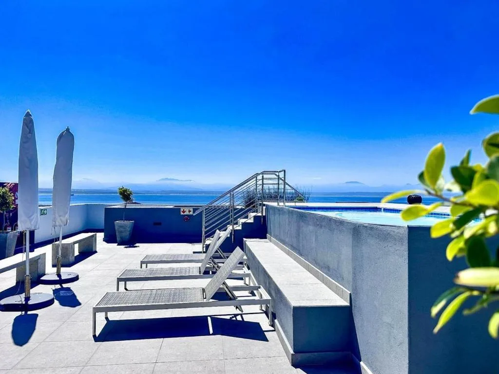 Sunbathing deck with loungers overlooking blue ocean and islands