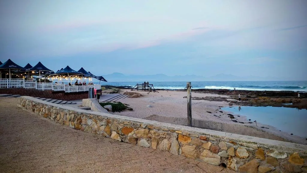 Beachfront property at dusk with ocean views and coastal landscape