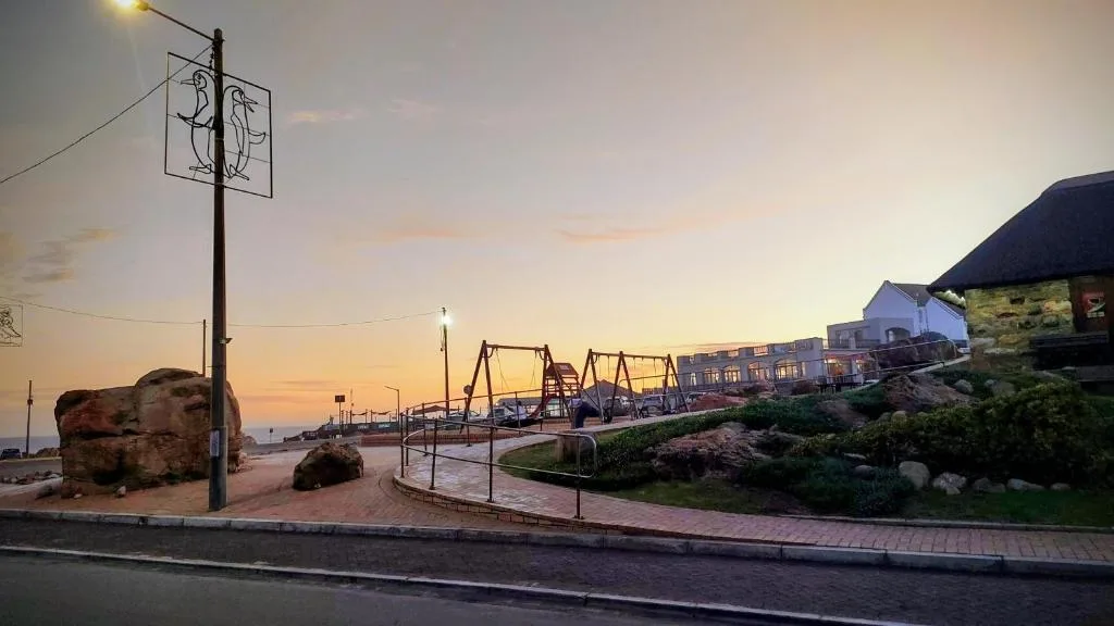 Sunset over Mossel Bay coastal town with properties and public playground