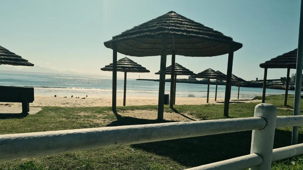 Beach with thatched umbrellas and ocean vista from seaside deck