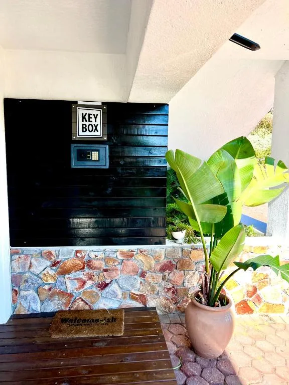 Entrance alcove with key box, plant in pot, and brick wall detail
