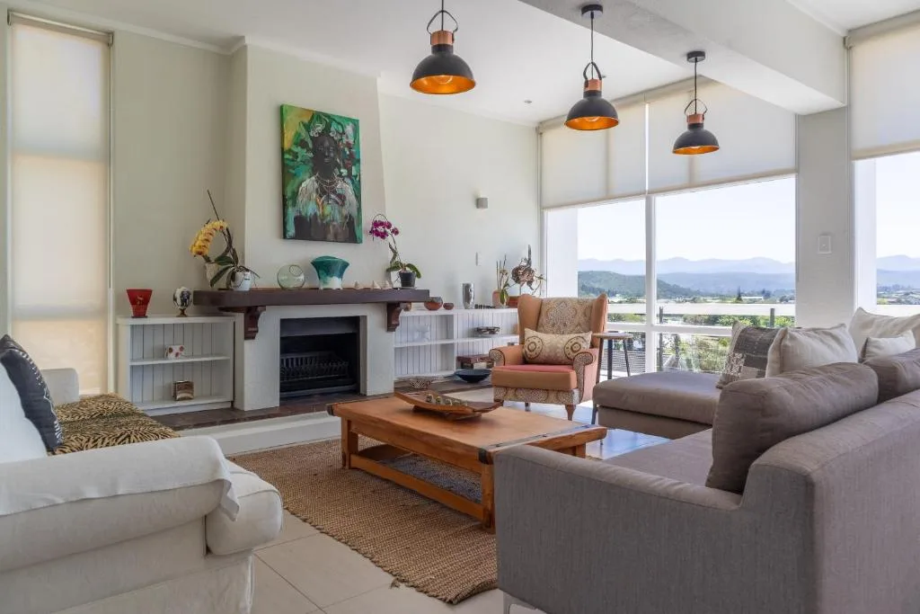 Spacious lounge with sofas, fireplace, and mountain views through large windows