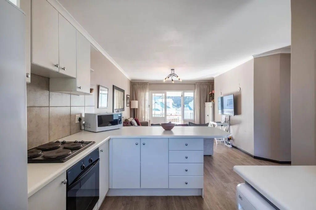 Modern kitchen with white cabinetry, gas stove, and island seating area