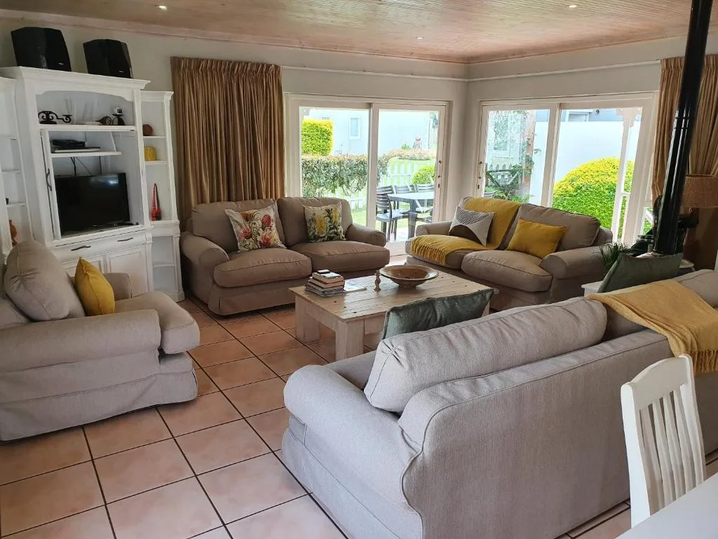 Spacious living room with comfortable seating and garden views through large windows