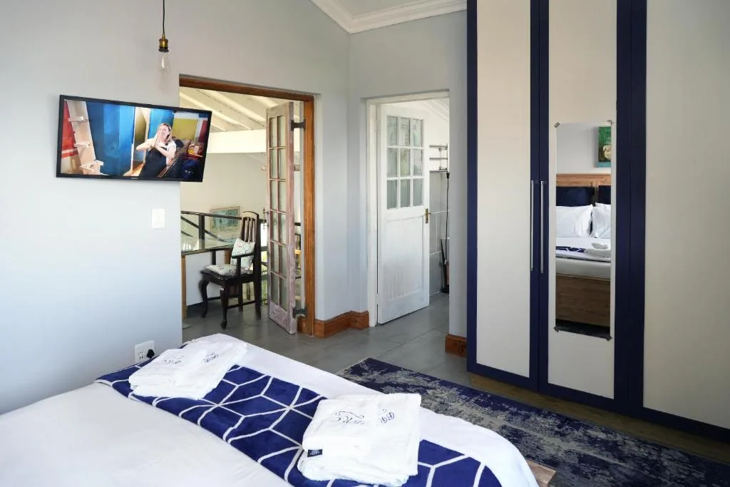 Modern bedroom with white bedding and navy geometric blanket accents
