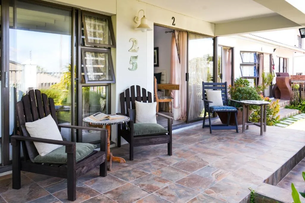 Spacious covered patio with Adirondack chairs and coastal views