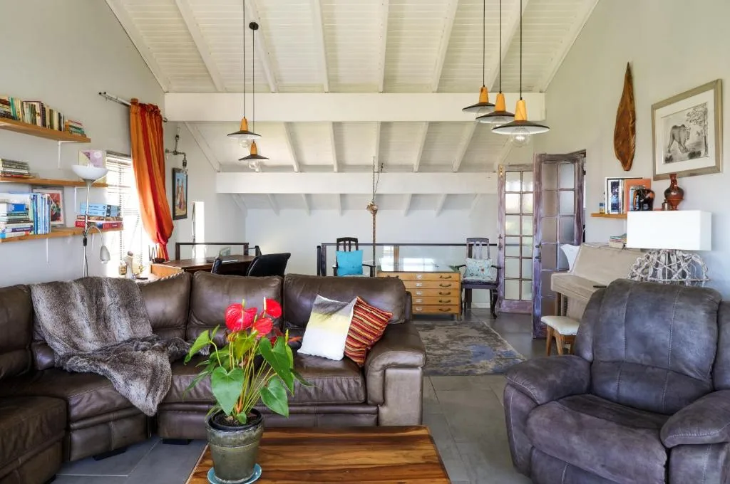 Spacious living room with leather sofas, pendant lighting, and coastal decor