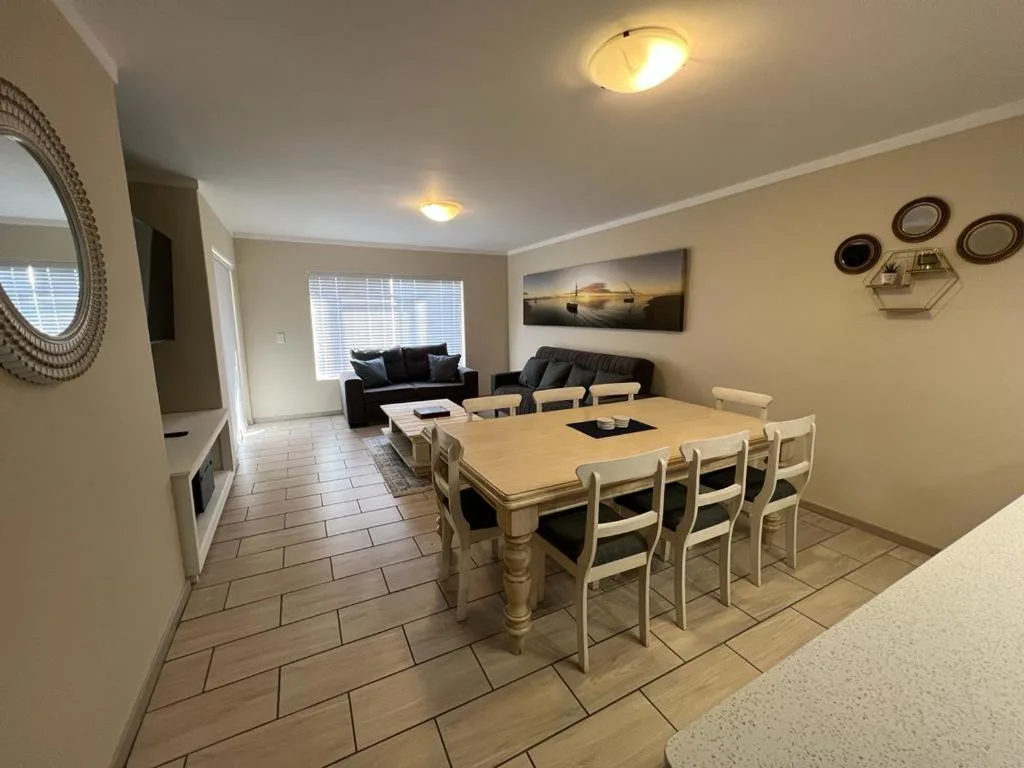 Dining table with six cream chairs in open-plan living space