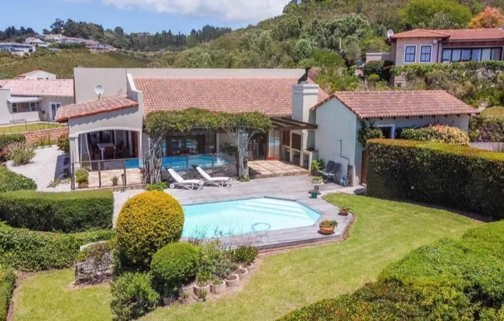 Modern holiday home with pool, manicured gardens, and terracotta roofing
