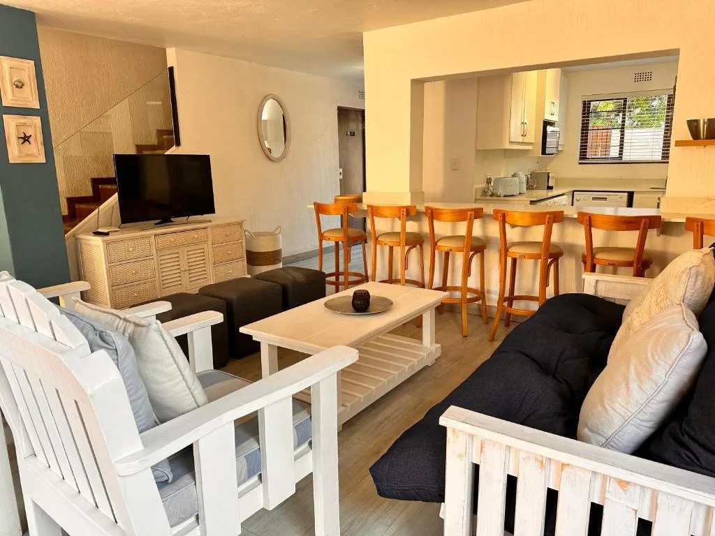 Open-plan lounge and dining area with comfortable seating and kitchen visible