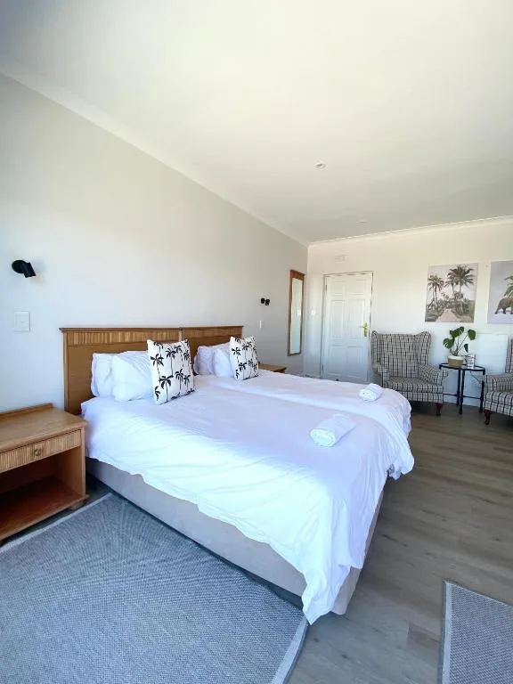 Bright bedroom with wooden bed, white linens, and decorative pillows