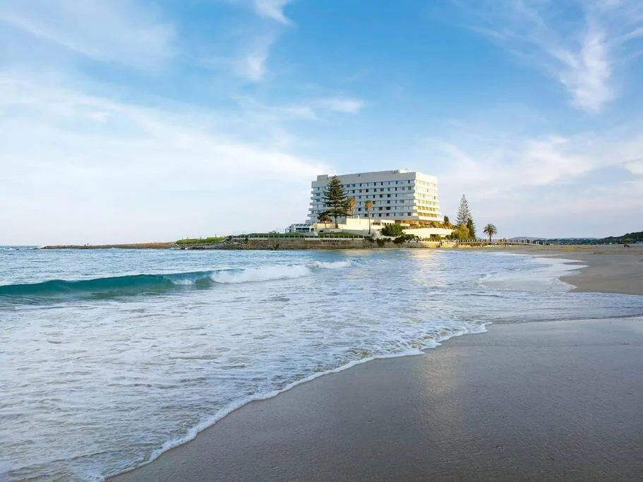 Beachfront property overlooking sandy beach and ocean waves
