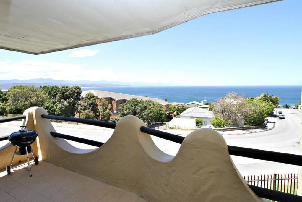 Ocean and mountain vista from shaded deck with coastal town below