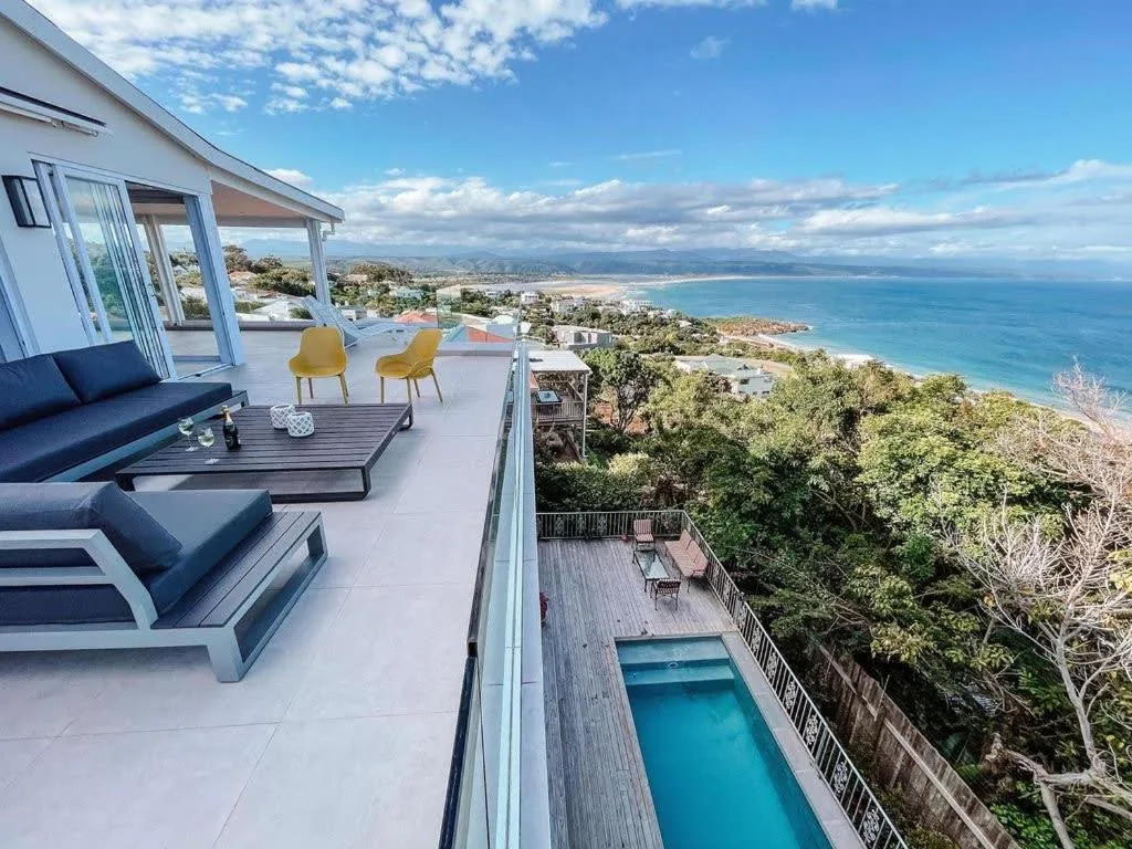 Coastal panorama with turquoise ocean, beach, and mountains from hilltop property