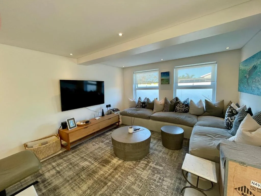 Spacious modern lounge with gray sectional sofa and wall-mounted television