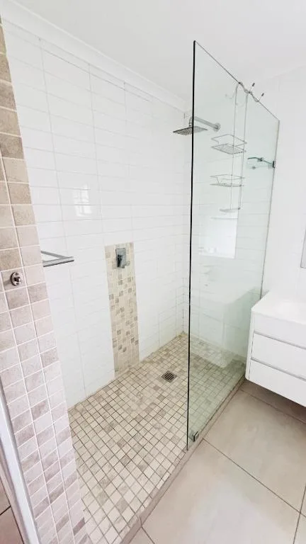 Modern walk-in shower with glass enclosure and tiled walls