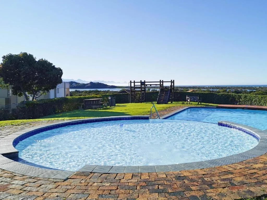 Two curved swimming pools with clear blue water and scenic lagoon views