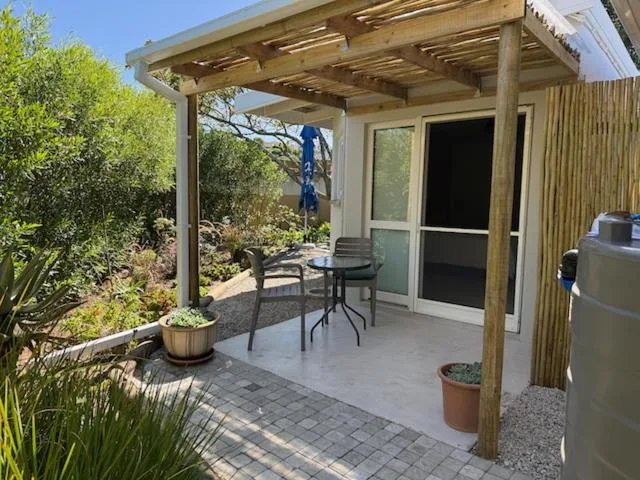 Wooden pergola deck with seating area and garden views