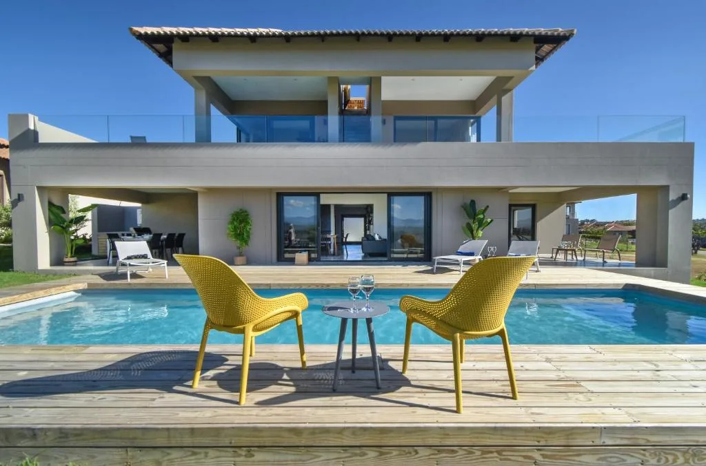 Modern villa swimming pool with yellow chairs and scenic mountain views
