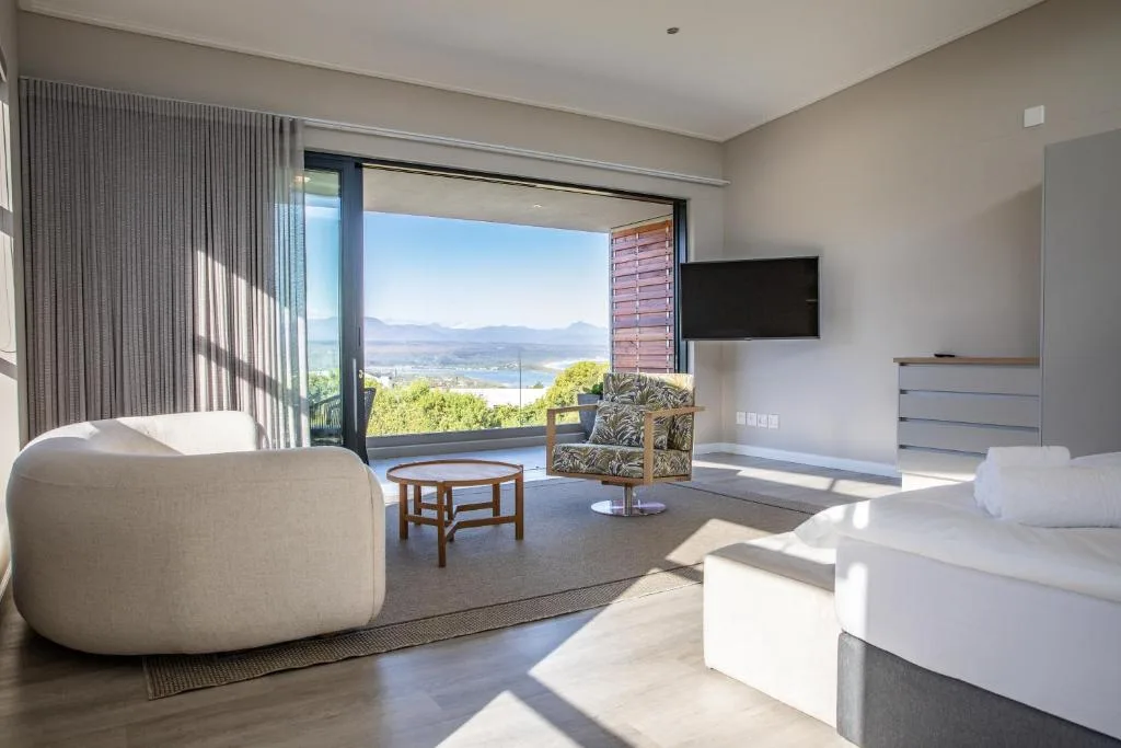 Modern lounge with curved seating and expansive bay view through sliding doors