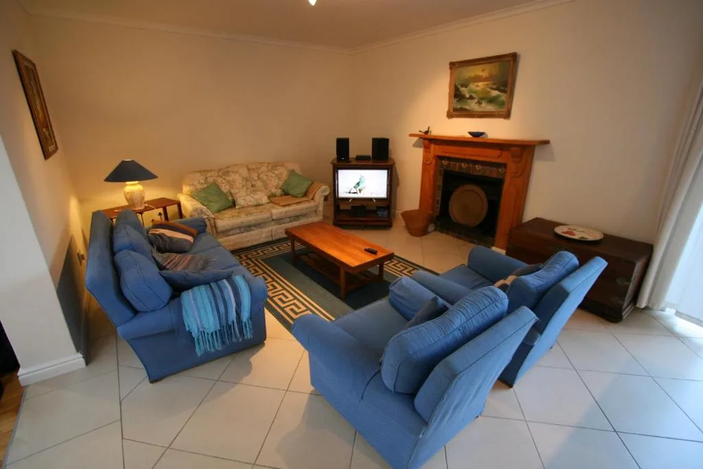 Spacious living room with blue sofas, fireplace, and entertainment center
