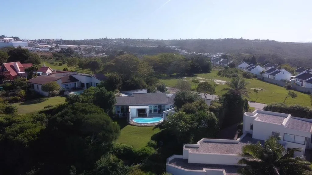 Aerial view of contemporary home with pool nestled in verdant Garden Route valley