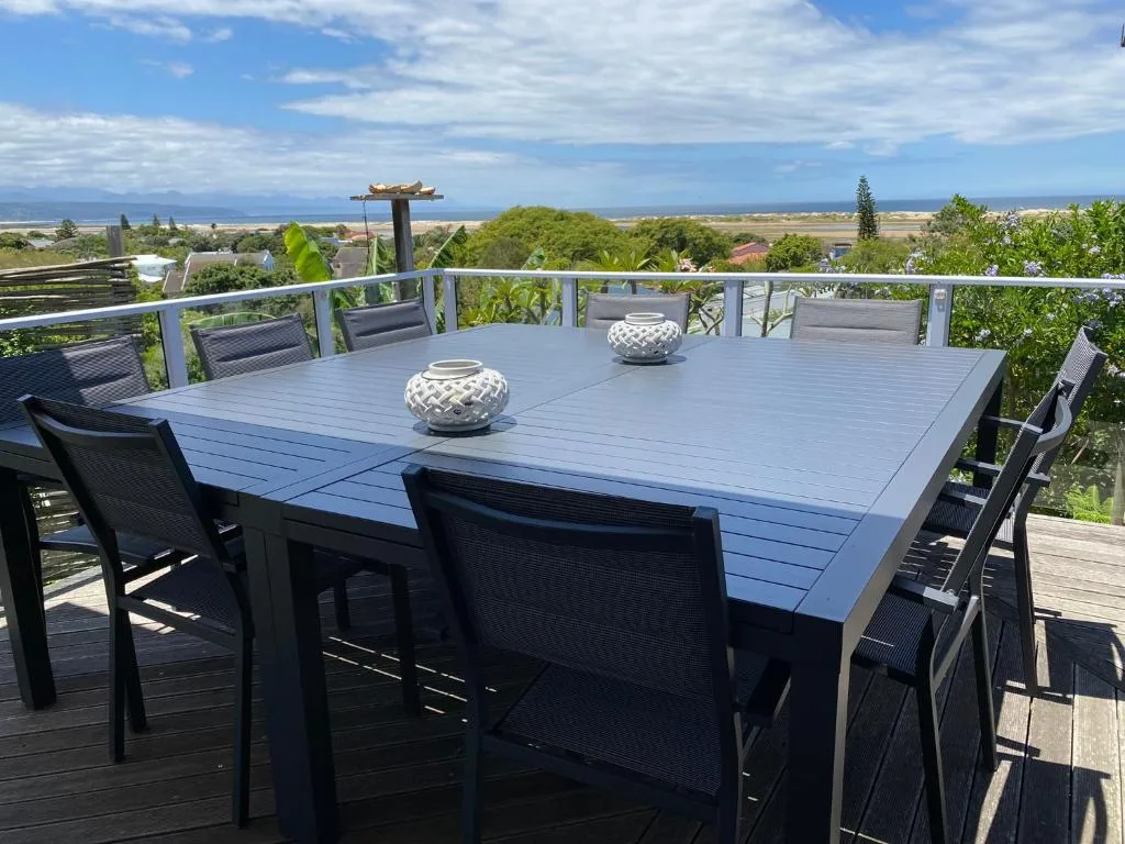 Elevated deck with dining table overlooking coastal valley landscape views