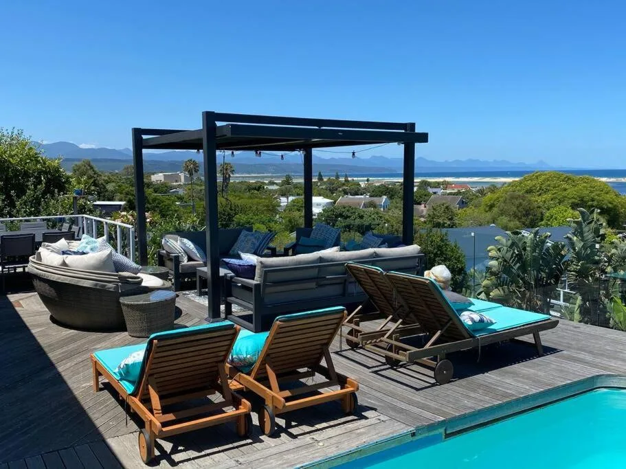 Spacious deck with loungers, pergola, and panoramic ocean and mountain views